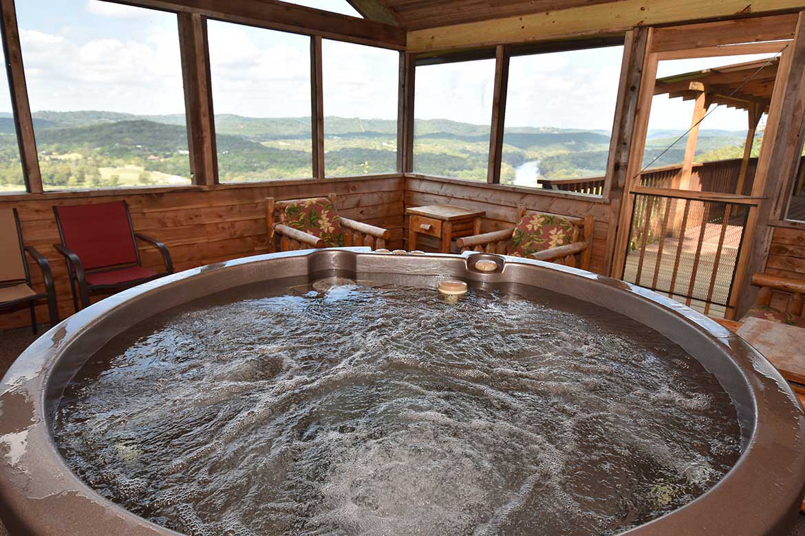 Relax in your hot tub on the private deck of your Eureka Springs, Arkansas cabin with a view of the White River